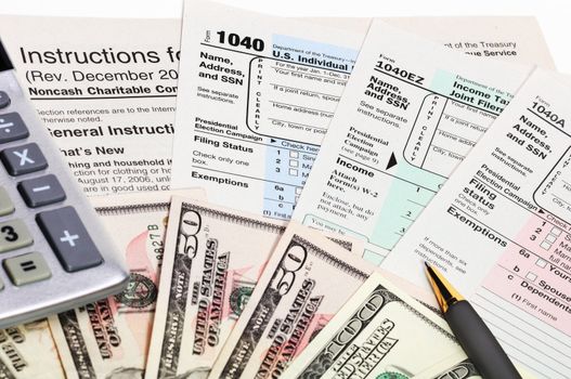 Tax forms 1040 with pen, calculator and money.