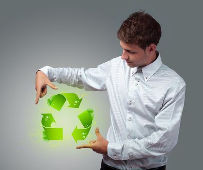 Young businessman holding virtual eco sign