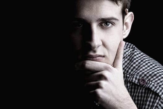 Portrait of young man thinking 2, black background 