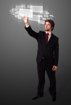 Businessman pressing high tech type of modern buttons on a virtual background