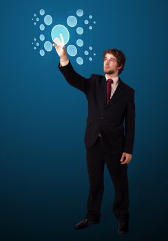 Businessman pressing high tech type of modern buttons on a virtual background