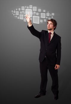 Businessman pressing high tech type of modern buttons on a virtual background