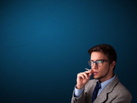 Handsome young man smoking cigarette with copy space
