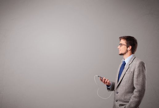 handsome young man singing and listening to music with copy space