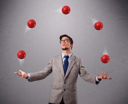 handsome young man standing and juggling with red balls