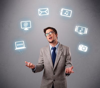funny boy standing and juggling with electronic devices icons