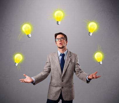 funny young man standing and juggling with light bulbs