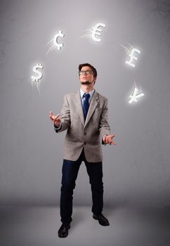 Attractie young man standing and juggling with currency icons