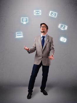 funny boy standing and juggling with electronic devices icons