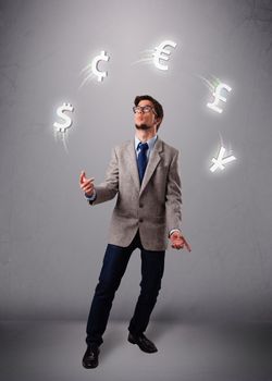 Attractie young man standing and juggling with currency icons