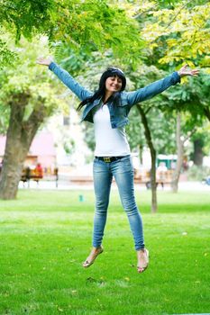 photo of young woman jamping on a grass