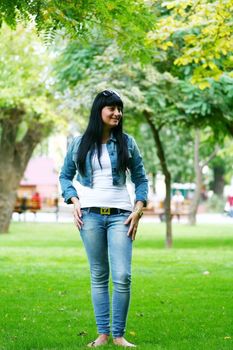 a young gorgeous woman is standing on the grass