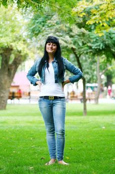 a young gorgeous woman is standing on the grass