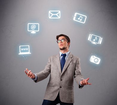 funny boy standing and juggling with electronic devices icons