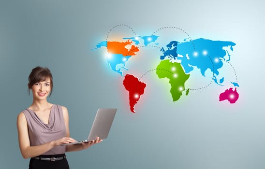 Beautiful young woman holding a laptop and presenting colorful world map