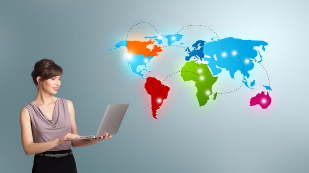 Beautiful young woman holding a laptop and presenting colorful world map