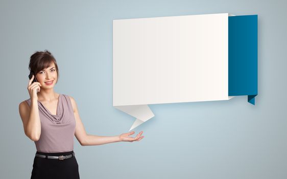 pretty young woman standing next to modern origami copy space and making phone call