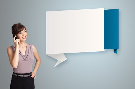 pretty young woman standing next to modern origami copy space and making phone call