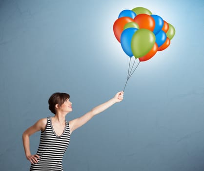 Pretty young woman holding colorful balloons