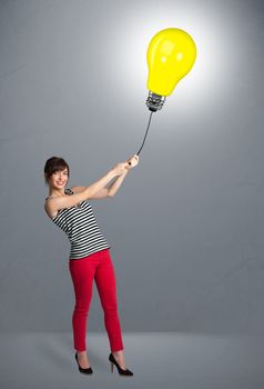 Pretty young woman holding a light bulb balloon