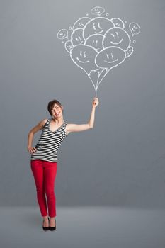 Happy young woman holding smiling balloons drawing