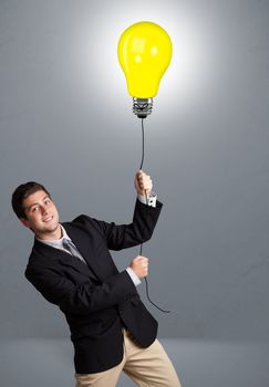 Handsome young man holding light bulb balloon