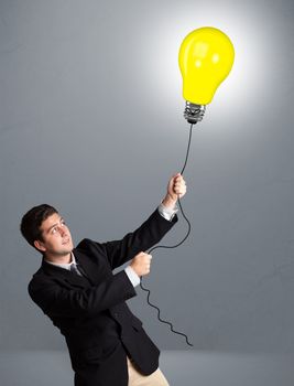 Handsome young man holding light bulb balloon