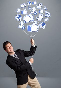 Attractive young man holding social icon balloon