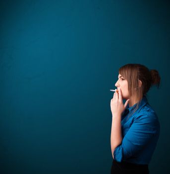 Beautiful young woman smoking cigarette with copy space