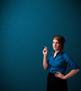 Beautiful young woman smoking cigarette with copy space