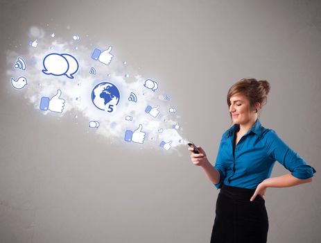 Pretty young girl holding a phone with social media icons in abstract cloud