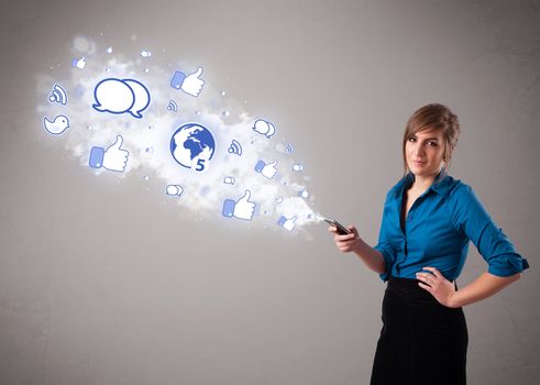 Pretty young girl holding a phone with social media icons in abstract cloud