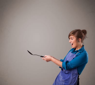 Beautiful young woman holding a spoon