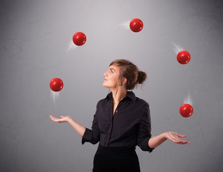 pretty young girl standing and juggling with red balls