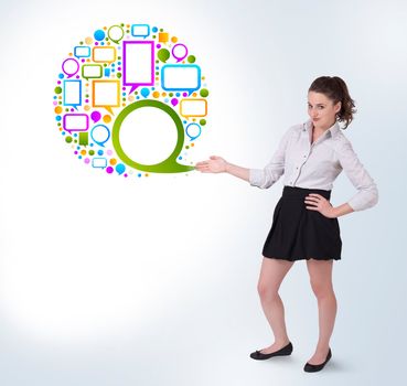 Young business woman presenting colourful speach bubble on bright background