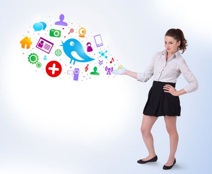 Young business woman presenting colourful social icons on bright background