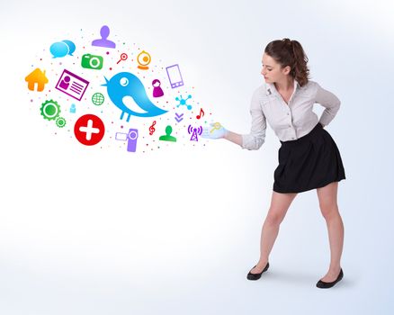 Young business woman presenting colourful social icons on bright background