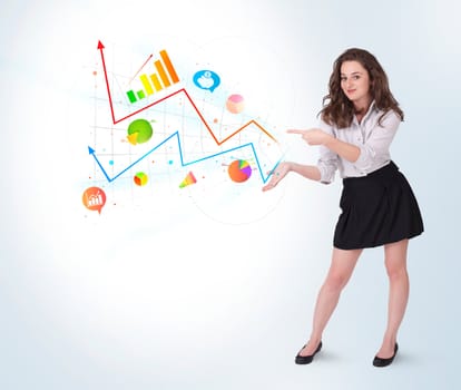 Young business woman presenting colorful charts and diagrams on bright background
 