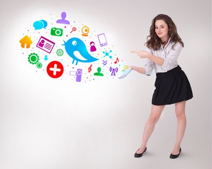 Young business woman presenting colourful social icons on bright background