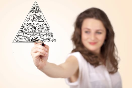 Young woman drawing a various food pyramid on whiteboard 
