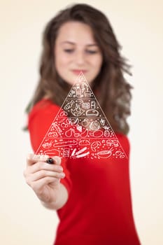 Young woman drawing a various food pyramid on whiteboard 