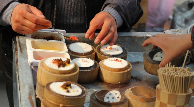 Chinese street food vendor preparing rice snacks
