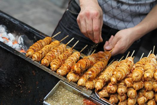 Chinese street food vendor seasoning tofu kebabs
