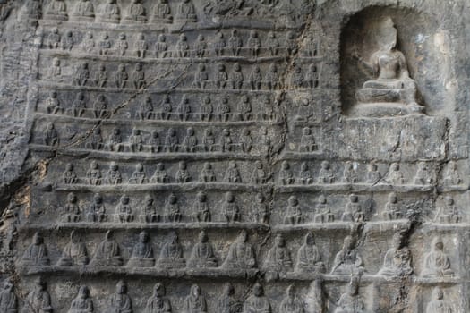 Wall of miniature Buddhas carved in Longmen Grottoes, a UNESCO World Heritage Site in Luoyang, China
