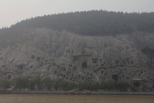 Longmen grottes, a UNESCO World Heritage Site, and Yi River, on a foggy day
