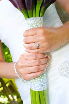 A beautiful bride in her white wedding dress holds her bouquet of flowers on her wedding day.