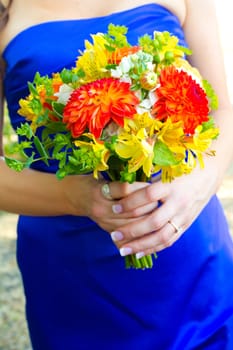 A bridesmaid holds her bouquet of beautiful flowers on a wedding day before the ceremony.