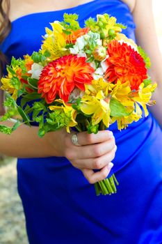 A bridesmaid holds her bouquet of beautiful flowers on a wedding day before the ceremony.