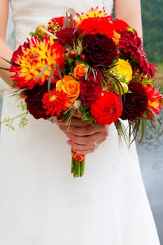 A beautiful bride in her white wedding dress holds her bouquet of flowers on her wedding day.