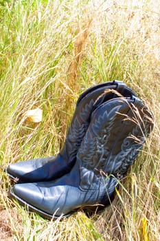 Cowboy boots in grass to be worn by a beautiful bride on her wedding day outdoors.